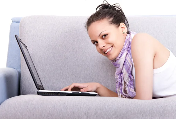 Девушка на диване с ноутбуком — стоковое фото