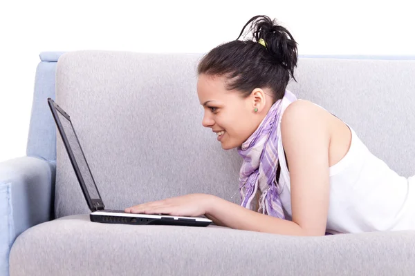 Mädchen liegt mit Laptop auf Sofa — Stockfoto