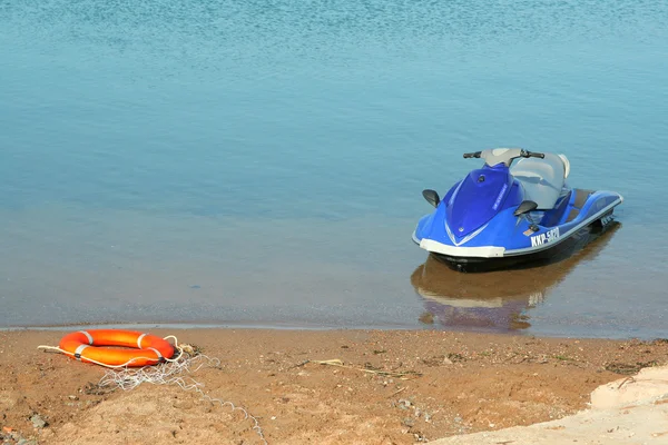 Скутер и спасательный круг на берегу — стоковое фото