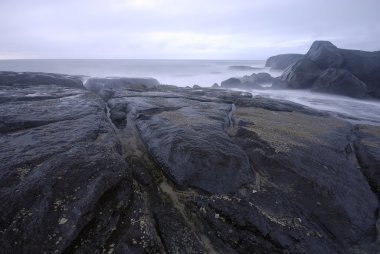 Rocks with a calm blue sea clipart