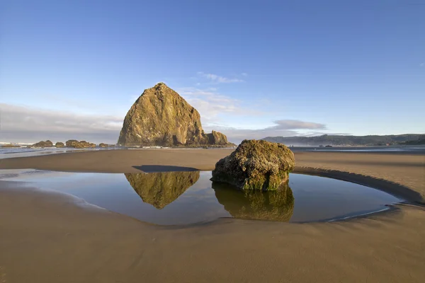 Reflektion av höstacken rock på kanon beach — Stockfoto