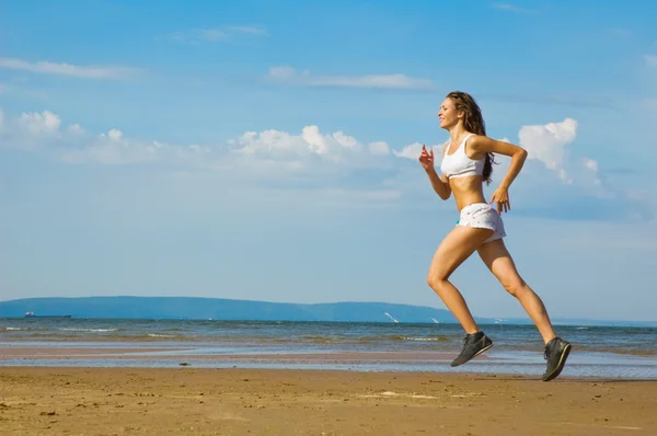 Giovane donna che corre da sola sulla spiaggia — Foto Stock