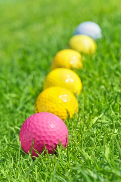 Zes golfballen op het groene gras — Stockfoto