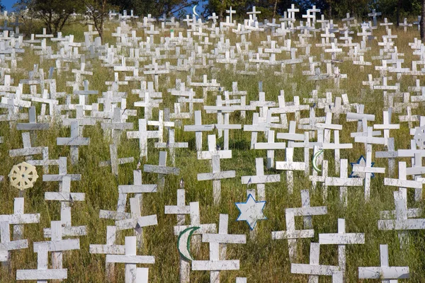 Белые кресты на склоне горы — стоковое фото