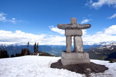 Whistler Peak inukshuk with snow and mountains clipart