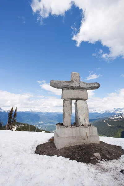Whistler Peak inukshuk with snow and mountains vertical — Stock Photo, Image