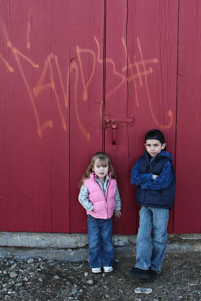 Små barn umgås nära en grungy vägg — Stockfoto