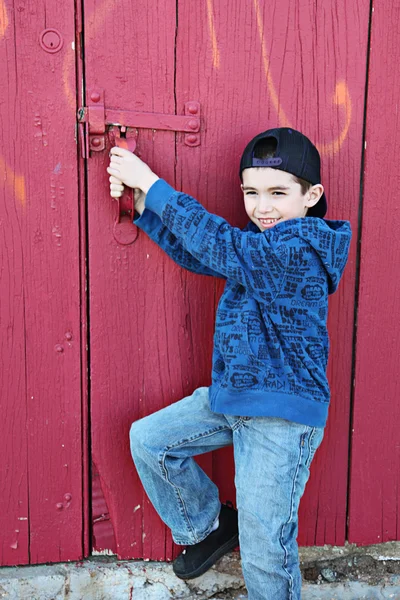 Niño pequeño pasando el rato cerca de una pared grumosa — Foto de Stock