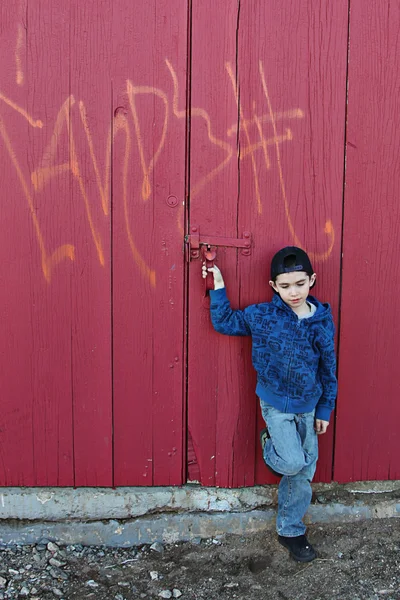 Giovane bambino appeso fuori vicino a un muro scontroso — Foto Stock