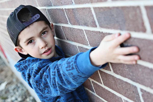 汚れた壁の近くに出かける若い子 — ストック写真