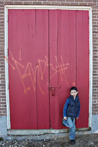 Giovane bambino appeso fuori vicino a un muro scontroso — Foto Stock