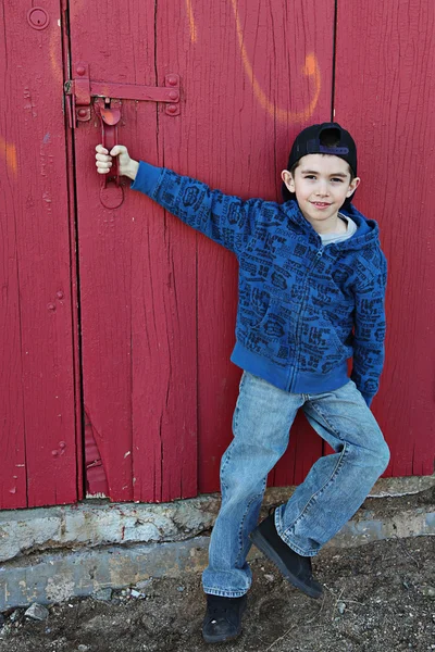 Young child hanging out near a grungy wall — Stock Photo, Image
