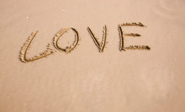 Liebe in den Sand am Strand geschrieben — Stockfoto