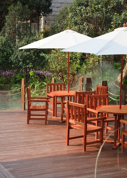 Dom patio ze stołem i krzesłami pod parasolem — Zdjęcie stockowe