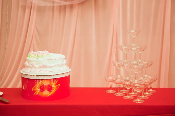 Svatební dort a sklenice na víno — Stock fotografie