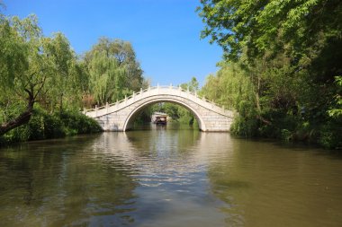 White stone footbridge in an Asian garden clipart