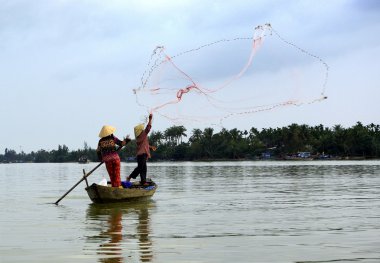 Two fishermen in action with their net clipart