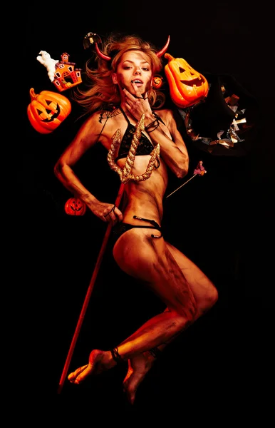 Beautiful devil with trident and Halloween accessories on black — Stock Photo, Image