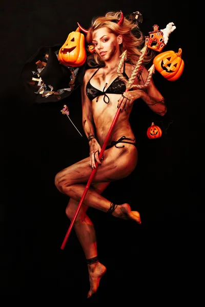 Mooie duivel met trident en halloween accessoires op zwart Rechtenvrije Stockfoto's