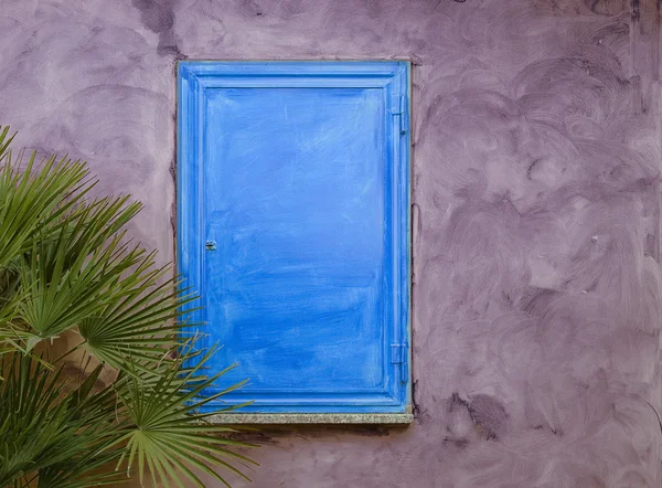 Modré dřevěné okenice na fialové zdi — Stock fotografie