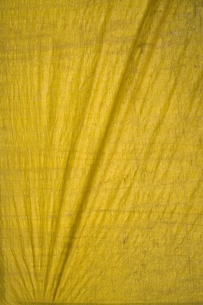 Yellow tarpaulin with folds — Stock Photo, Image