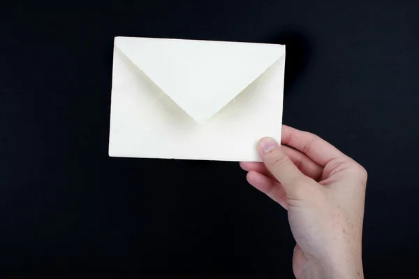 Mão segurando um envelope branco — Fotografia de Stock
