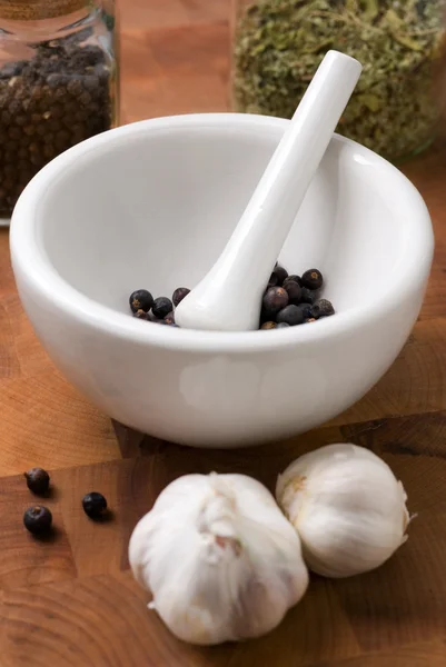 Juniper in mortar and pestle with garlic — Stock Photo, Image