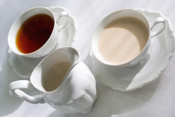 Duas xícaras de chá e jarro de leite . — Fotografia de Stock