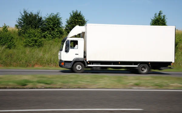 Witte vrachtwagen versnellen op snelweg — Stockfoto