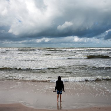 Man looking into stormy sea clipart