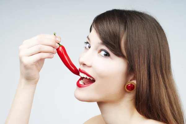 Sexy woman biting a chili pepper — Stock Photo, Image