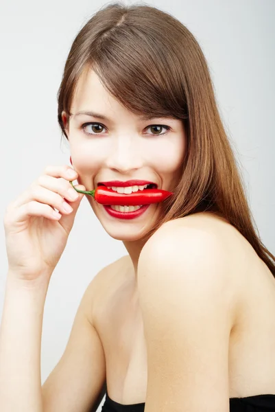 Sexy kobieta gryzienie papryka chili — Zdjęcie stockowe