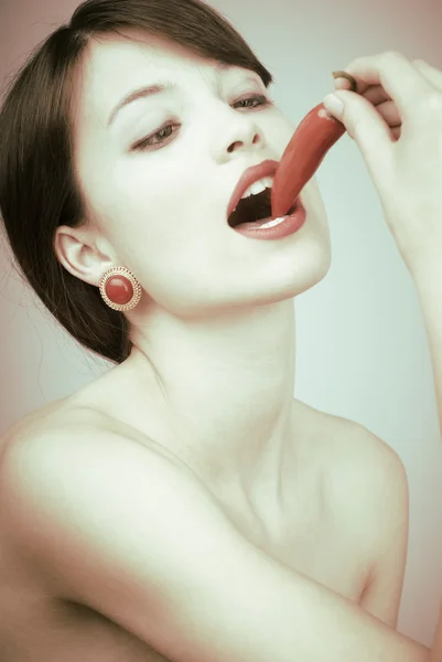 セクシーな女性、唐辛子をかむ — ストック写真