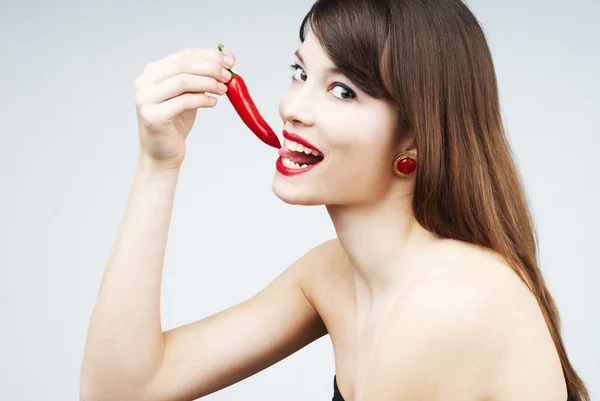 Sexy woman biting a chili pepper Royalty Free Stock Photos