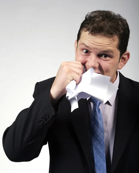 Сумасшедший бизнесмен ест бумагу — стоковое фото