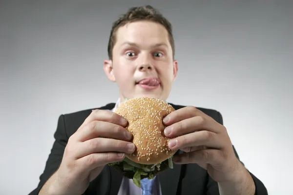 Głodny biznesmen posiadania burger — Zdjęcie stockowe