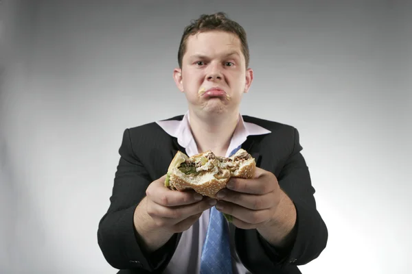 Homme d'affaires malheureux manger un hamburger — Photo