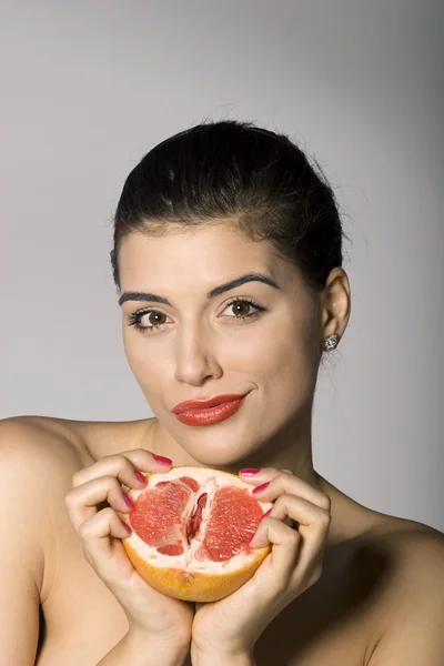 Vacker kvinna med en grapefrukt skiva — Stockfoto