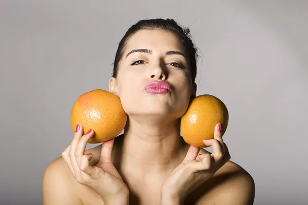 Kvinna med grapefrukt skivor Stockbild