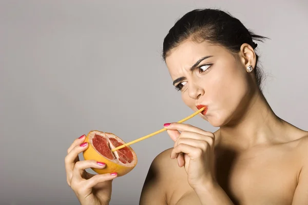 Vrouw met een schijfje grapefruit Stockafbeelding