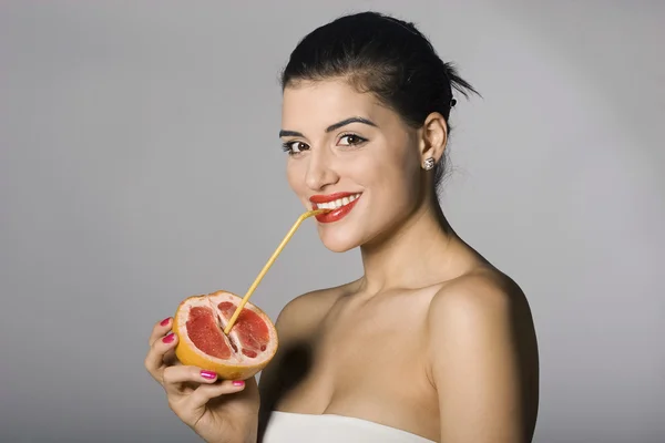 Sexig kvinna med en grapefruktskiva Royaltyfria Stockbilder