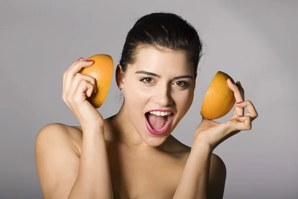 Lächelnde Frau mit Grapefruitscheiben lizenzfreie Stockfotos