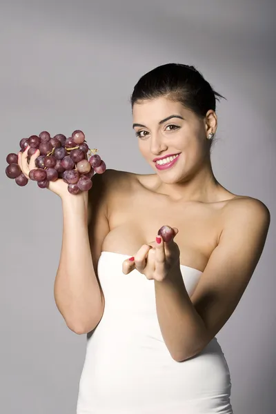 Mujer sosteniendo uvas rojas — Foto de Stock