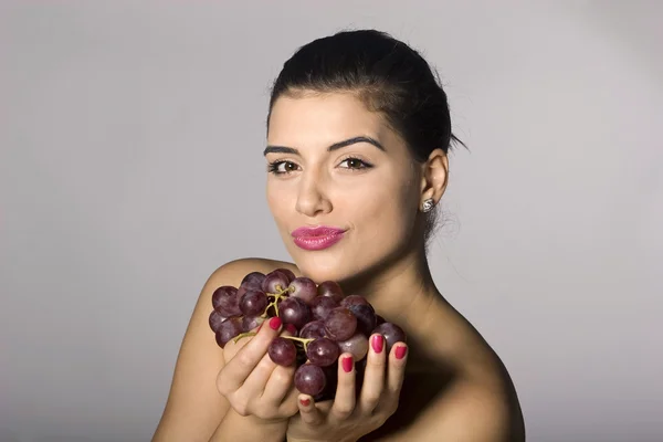 Mulher segurando uvas vermelhas — Fotografia de Stock