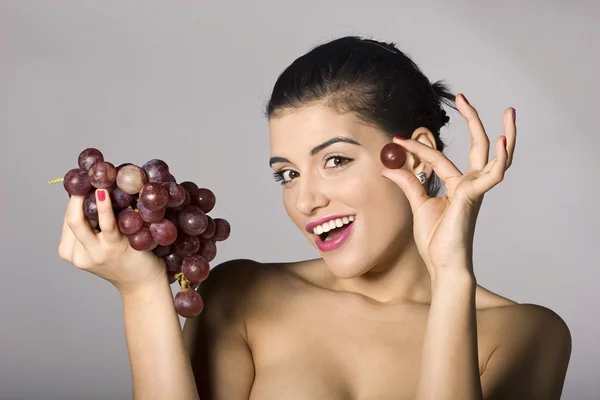 Vrouw bedrijf rode druiven — Stockfoto