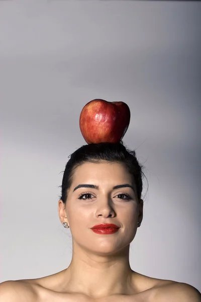 Žena drží jablko na hlavu — Stock fotografie