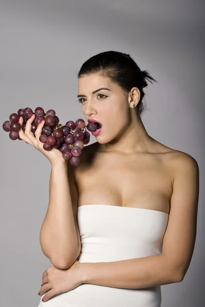 Donna che detiene uva rossa Foto Stock