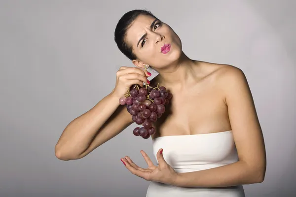 Femme tenant des raisins rouges Image En Vente