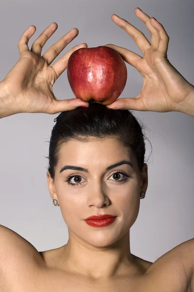 Femme tenant une pomme sur la tête Images De Stock Libres De Droits