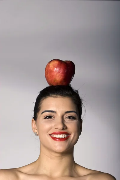 Mujer sosteniendo una manzana en su cabeza Imagen De Stock